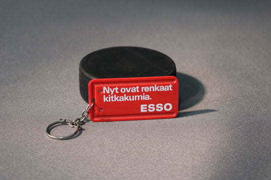 Esso avaimenperä punaisella taustalla ja tekstillä ”Nyt renkaat ovat kitkakumia”