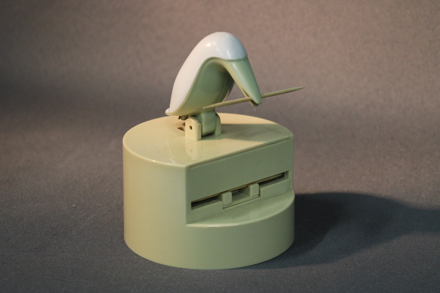 Hammastikkujen annostelija käytössä, lintu nostaa hammastikun esiin.