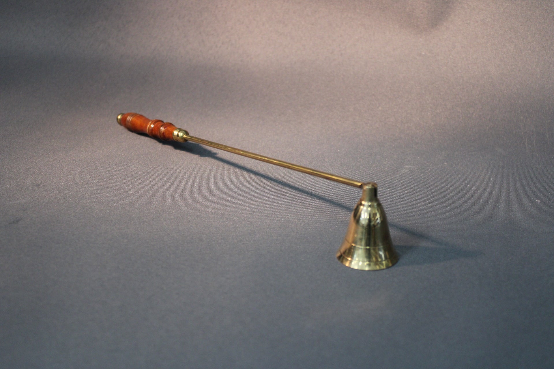 Messinkinen kynttilänsammutin, jossa puinen kahva