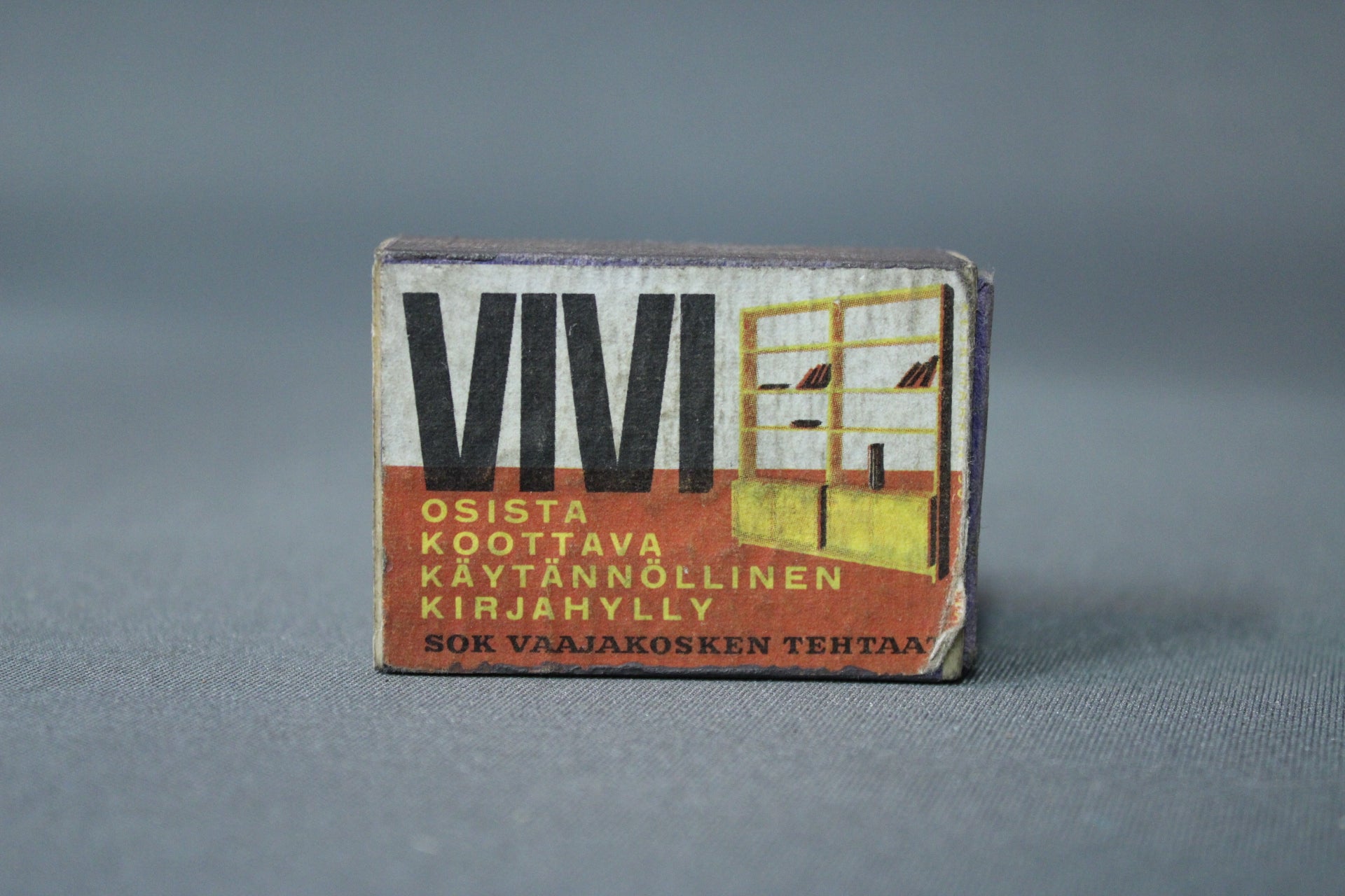 VIVI kirjahylly -mainos tulitikkurasia