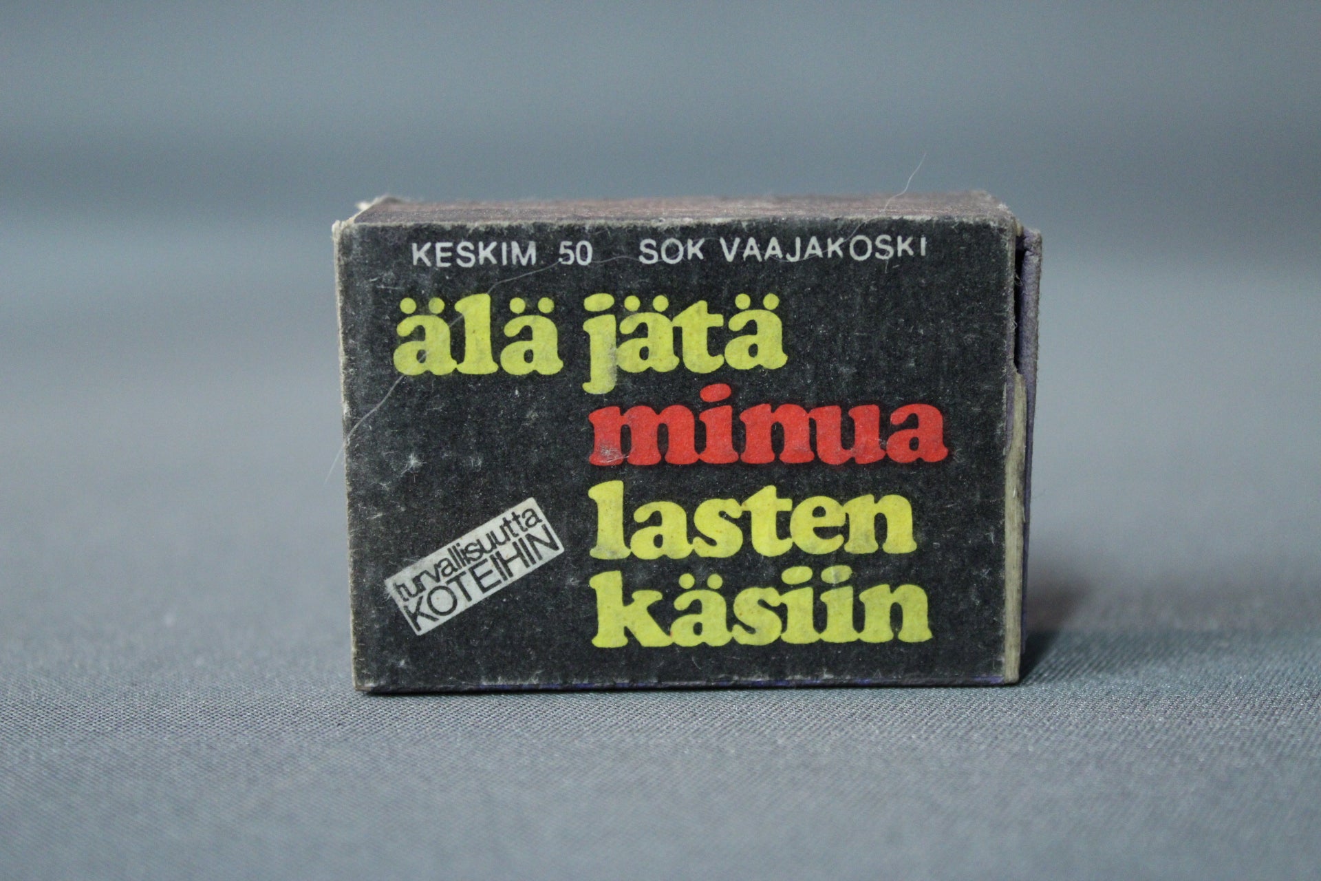 Musta tulitikkurasia ”Älä jätä minua lasten käsiin” -varoitustekstillä