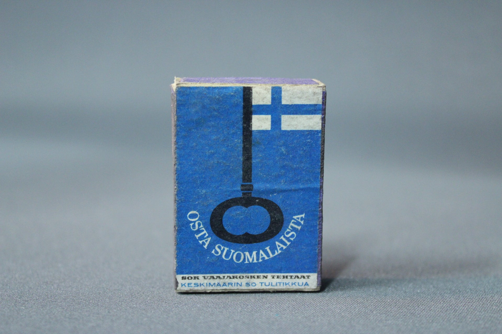 Osta suomalaista -teemainen tulitikkurasia, sininen lippuaihe