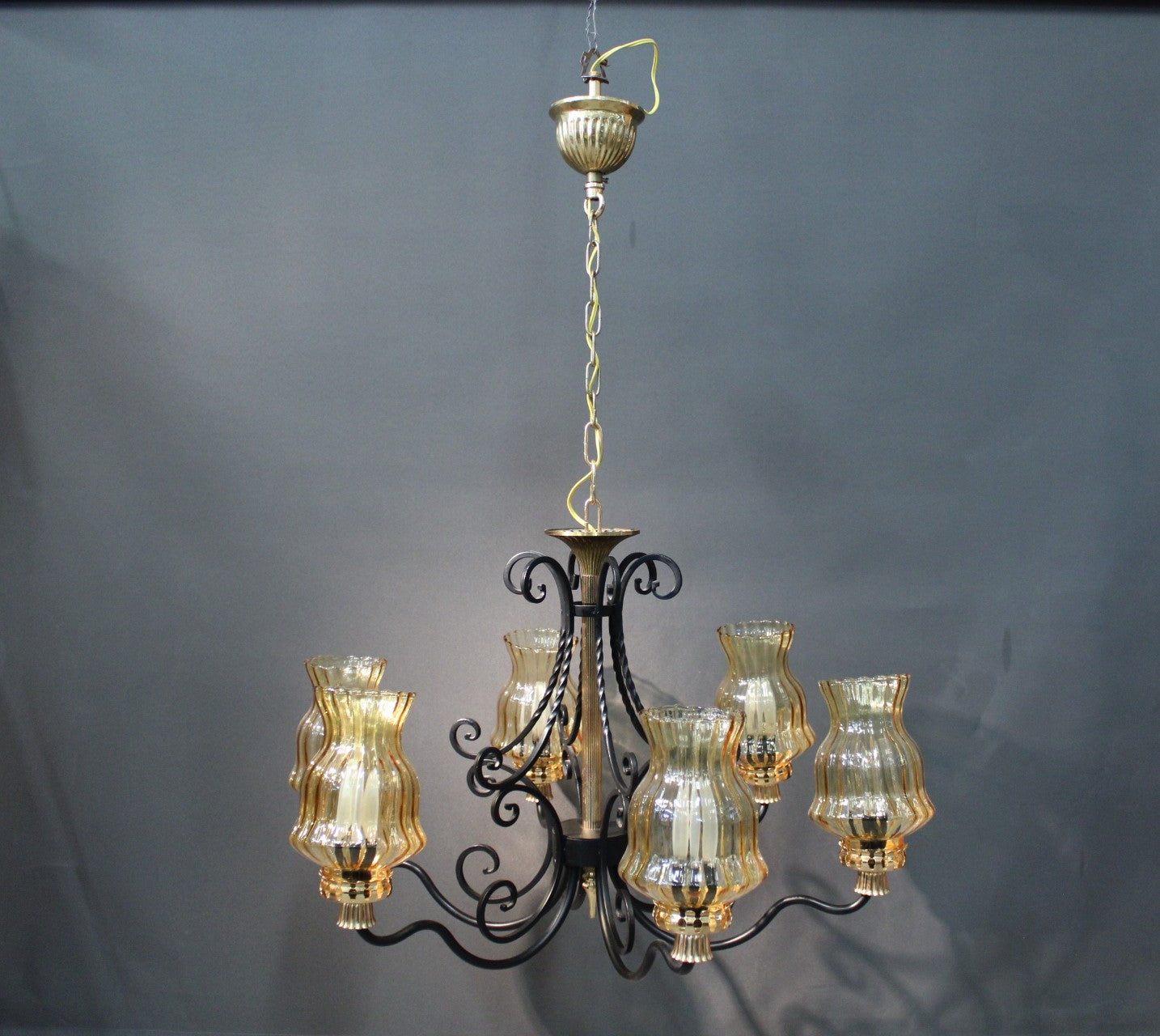 Musta metallinen kattokruunu ja kullan sävyiset yksityiskohdat