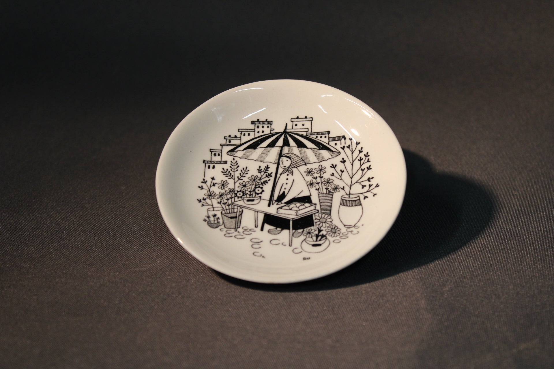 Arabia Emilia seinälautanen Torimyyjä, Raija Uosikkisen mustavalkoinen kuvitus