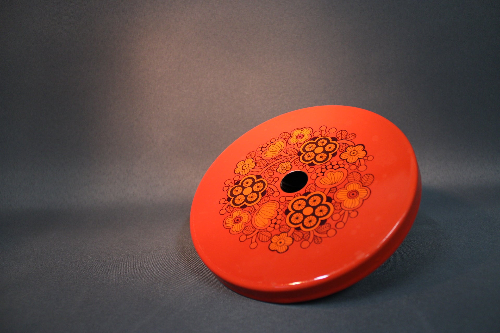 Finel liesilevyn suojus Primavera-kuviolla, Raija Uosikkisen suunnittelema punainen emaloitu keittiöesine