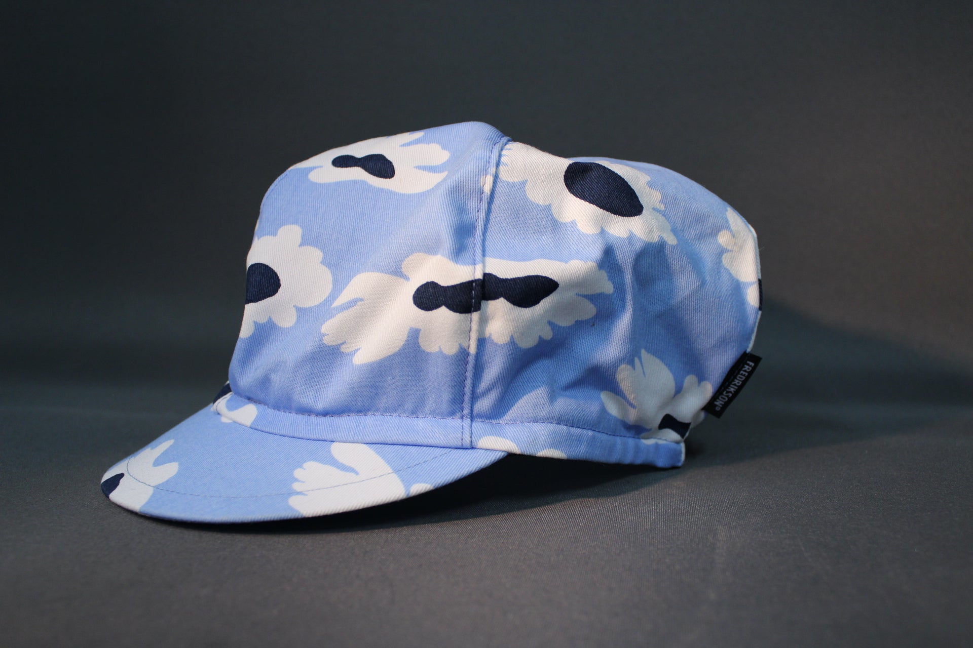 Fredrikson lippalakki sivusta, vaaleansininen kuosillinen päähine