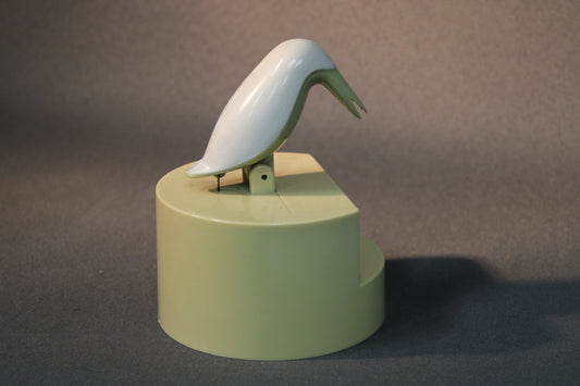 Hammastikkuannostelija sivulta kuvattuna, lintufiguuri kallistettuna.