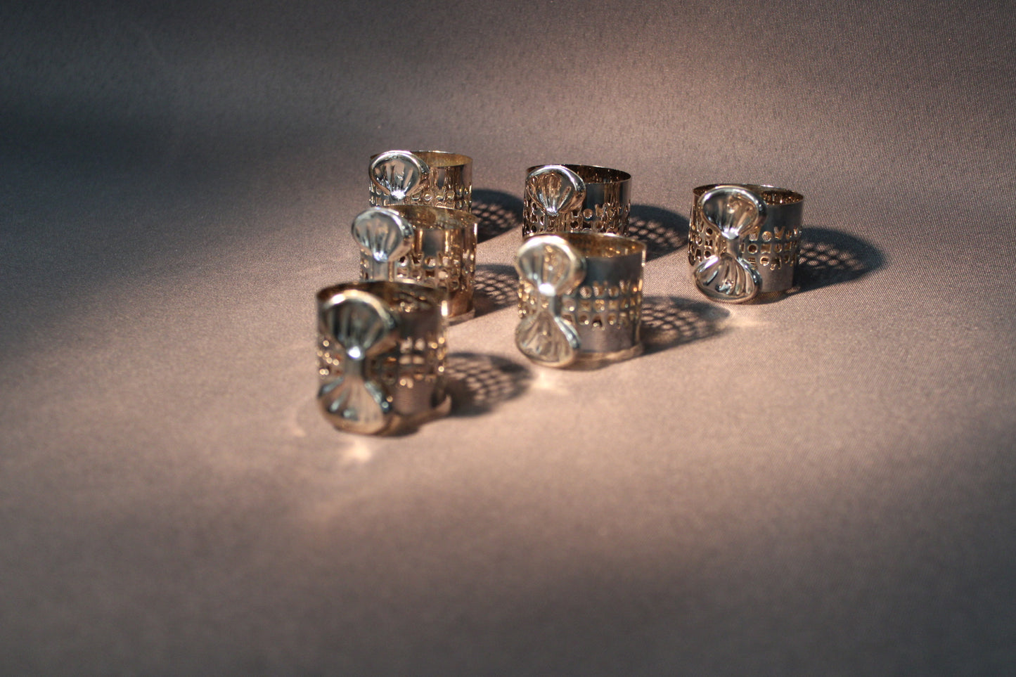 Hopeoidut lautasliinarenkaat ryhmässä, klassinen kattauksen yksityiskohta