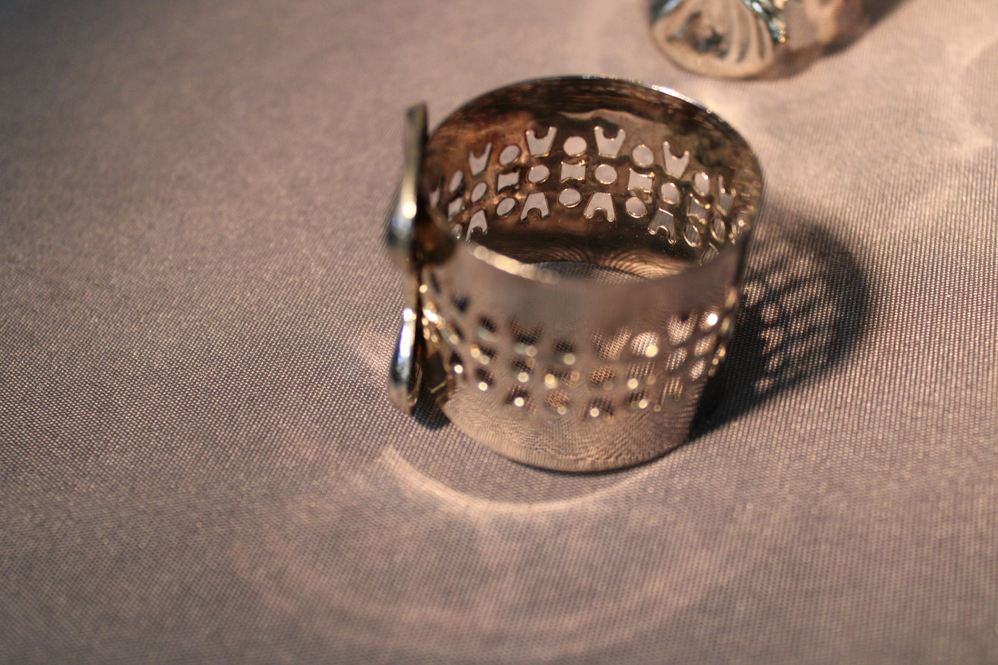 Hopeoitu lautasliinarengas sivulta, perforoitu metallirakenne