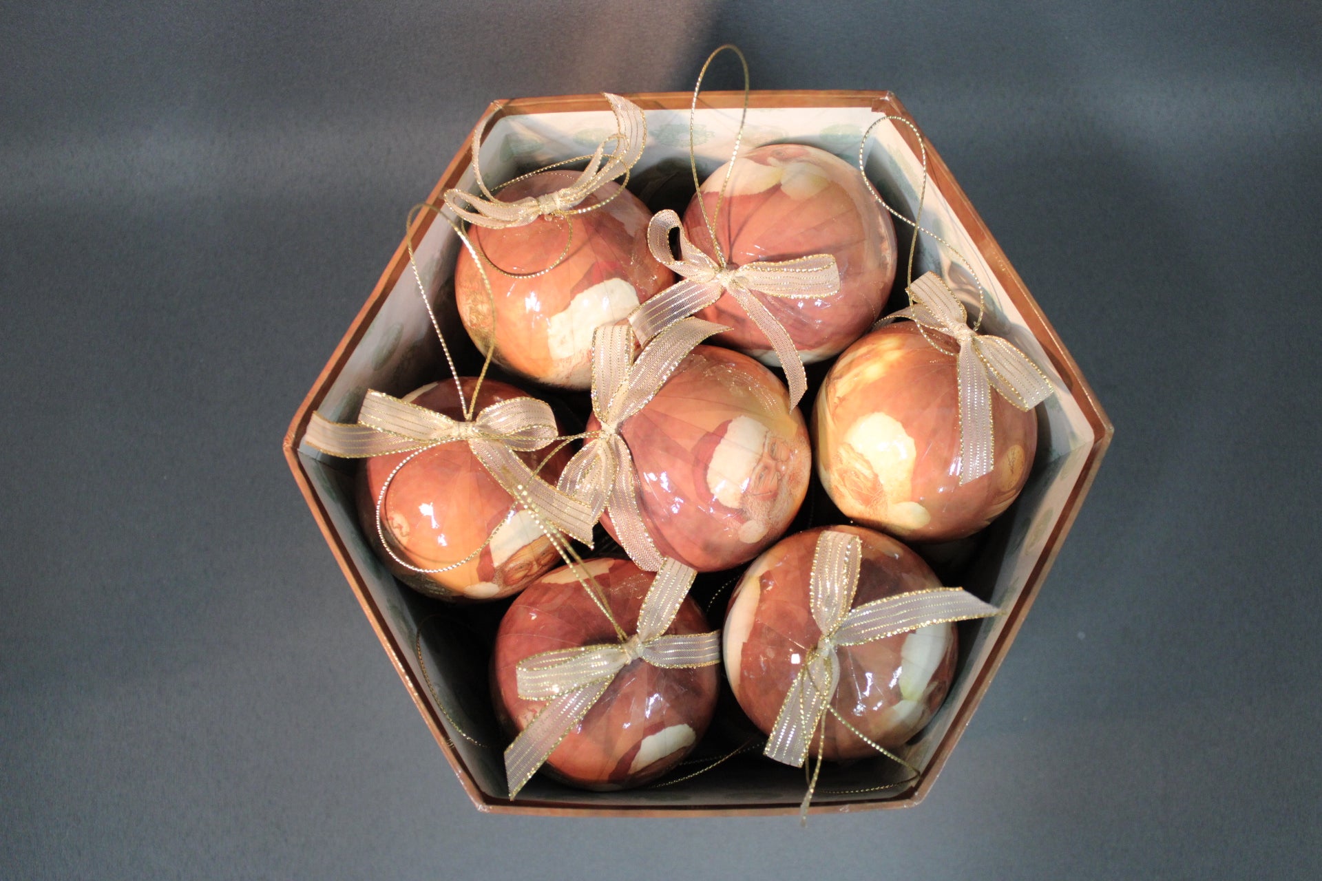 Joulupukki-aiheiset joulupallot ylhäältä kuvattuna, kultaiset rusetit