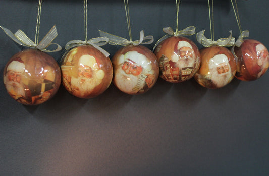 Ripustettuna roikkuvat joulupallot perinteisellä joulupukki-kuvituksella