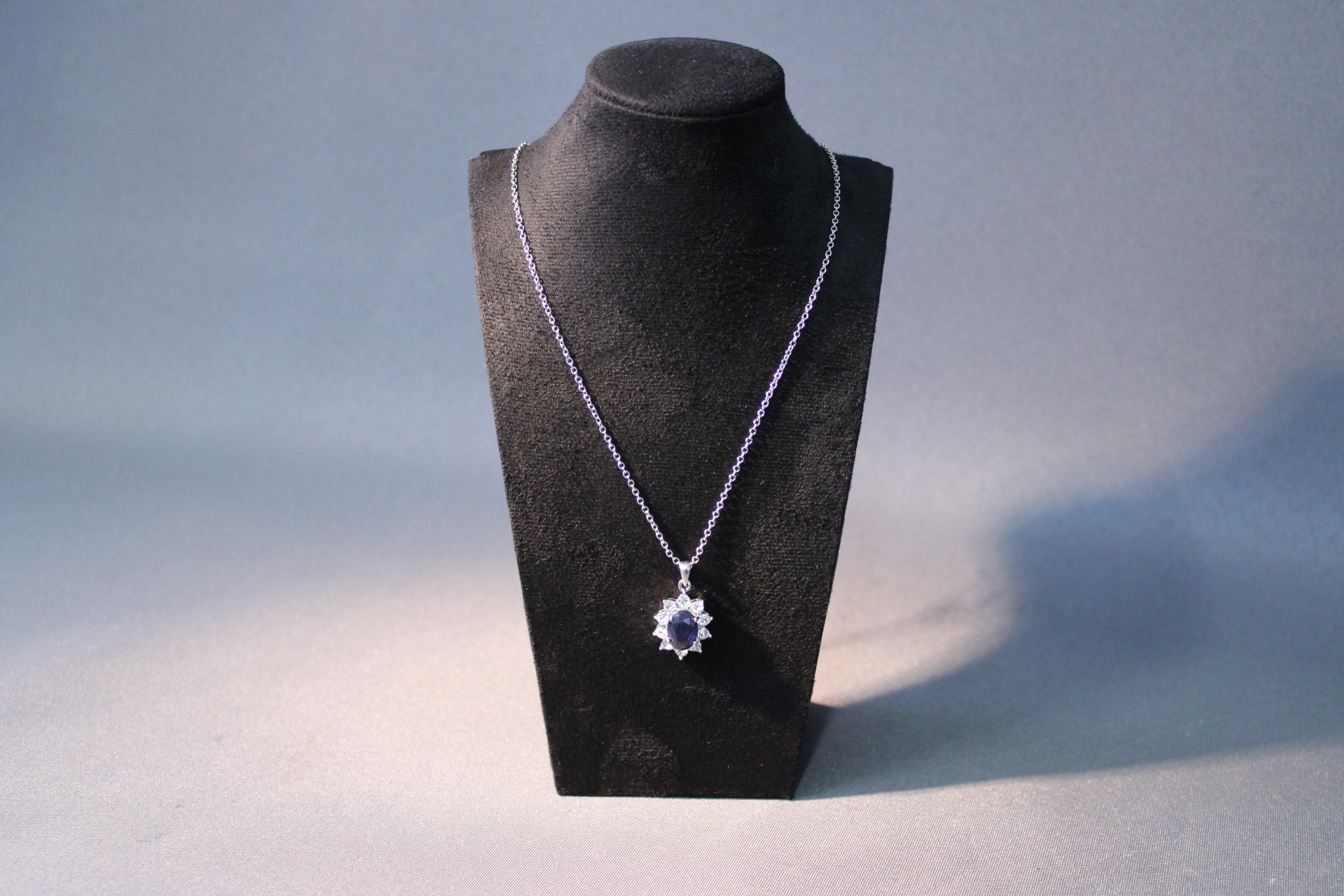 Hopeansävyinen kaulakoru sinisellä kivellä ja kirkkailla koristekivillä