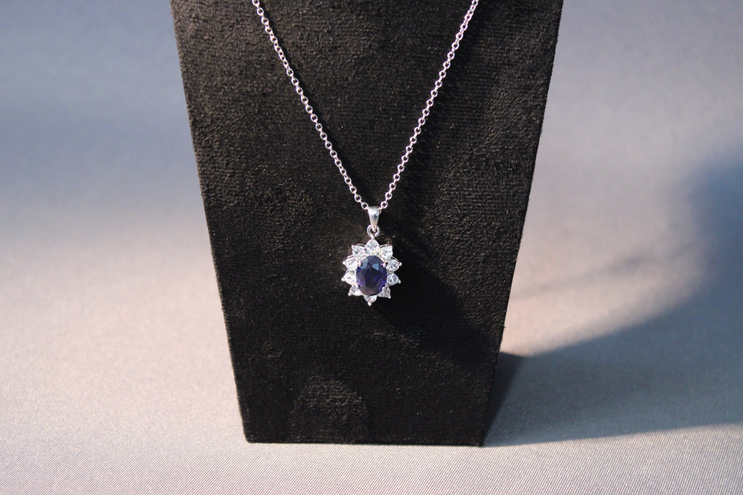 Lähikuva sinisestä kiviriipuksesta kirkkailla Swarovskin & Zircon-elementeillä