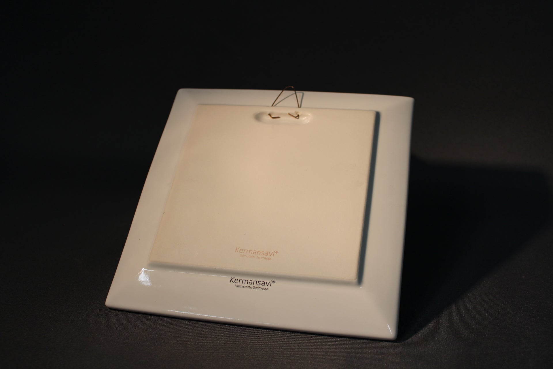 Kermansaven Lapin kevät -seinälautanen takaosa, ripustus ja leimat