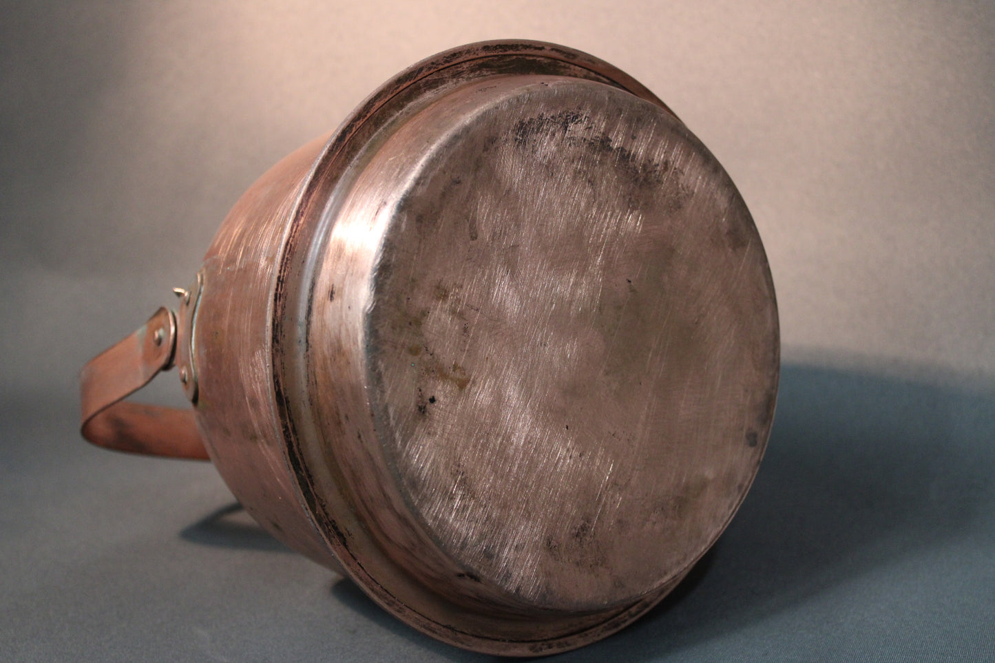 Kuparipannun pohja, näkyvissä käytön jälkiä ja patinaa