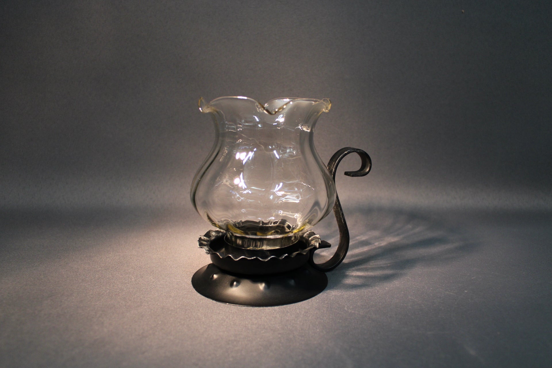 Lasinen kynttilälyhty metallijalalla, kirkas lasi ja musta metalli, ajaton sisustusesine