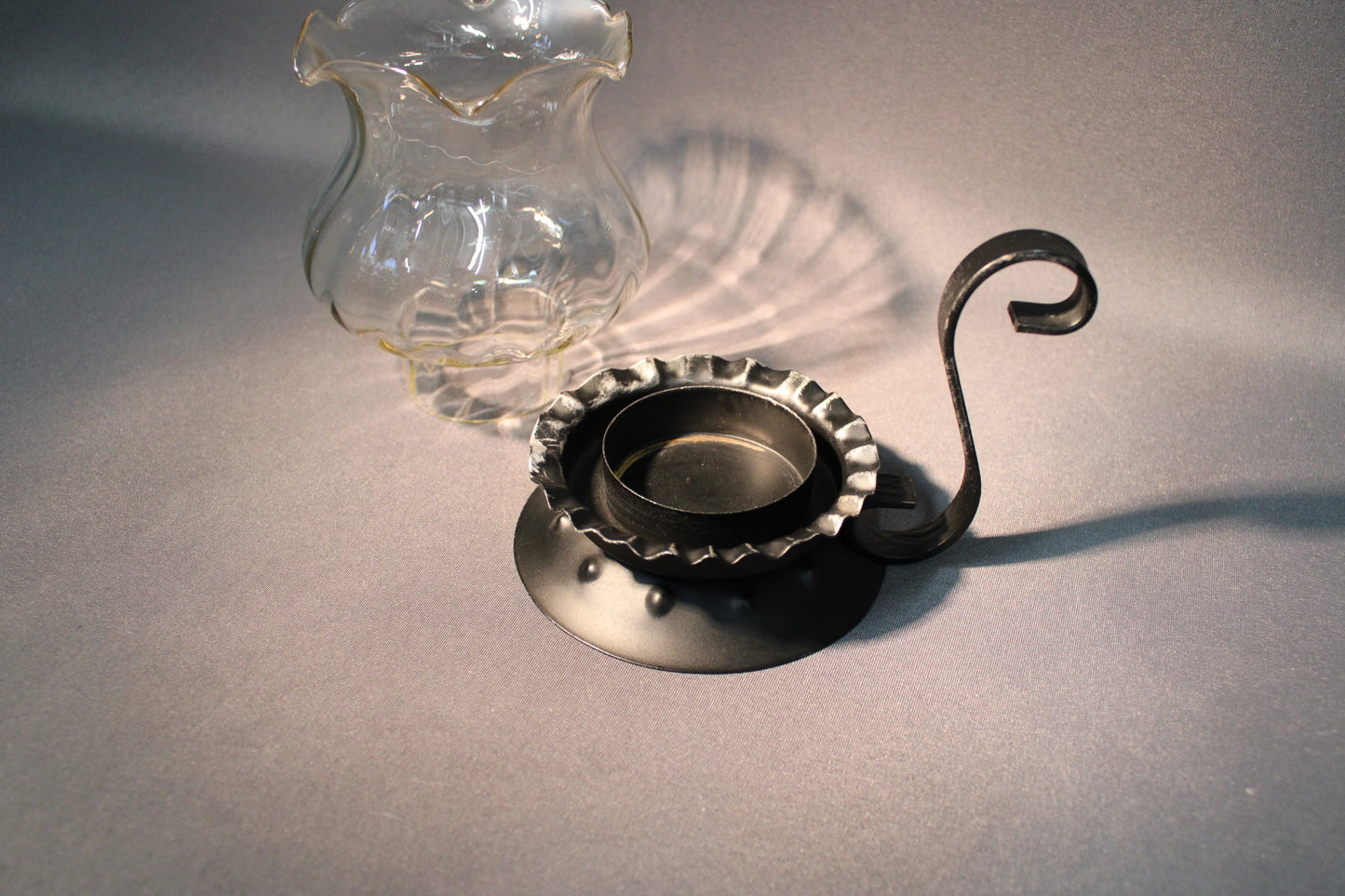 Kynttilälyhdyn irrotettava lasiosa ja metallijalka, kirkas lasi ja musta metalli