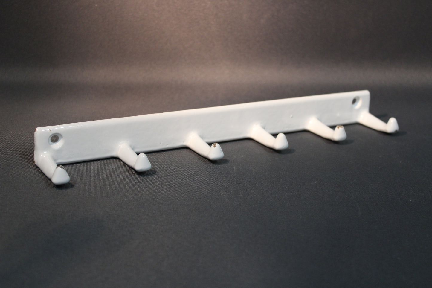 Valkoinen emaloitu metallinaulakko, viisi koukkua, edestä kuvattuna