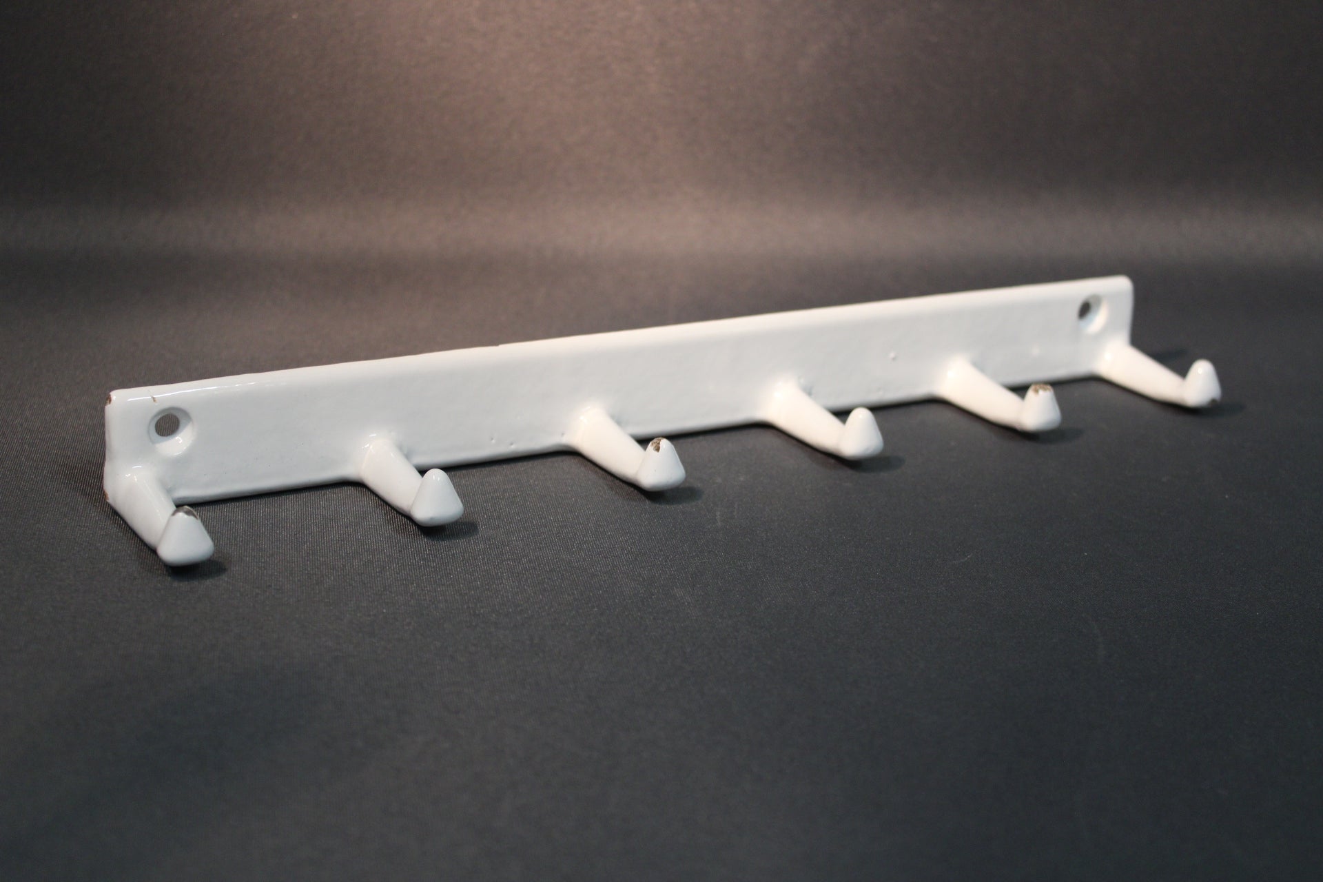 Valkoinen emaloitu metallinaulakko, viisi koukkua, edestä kuvattuna