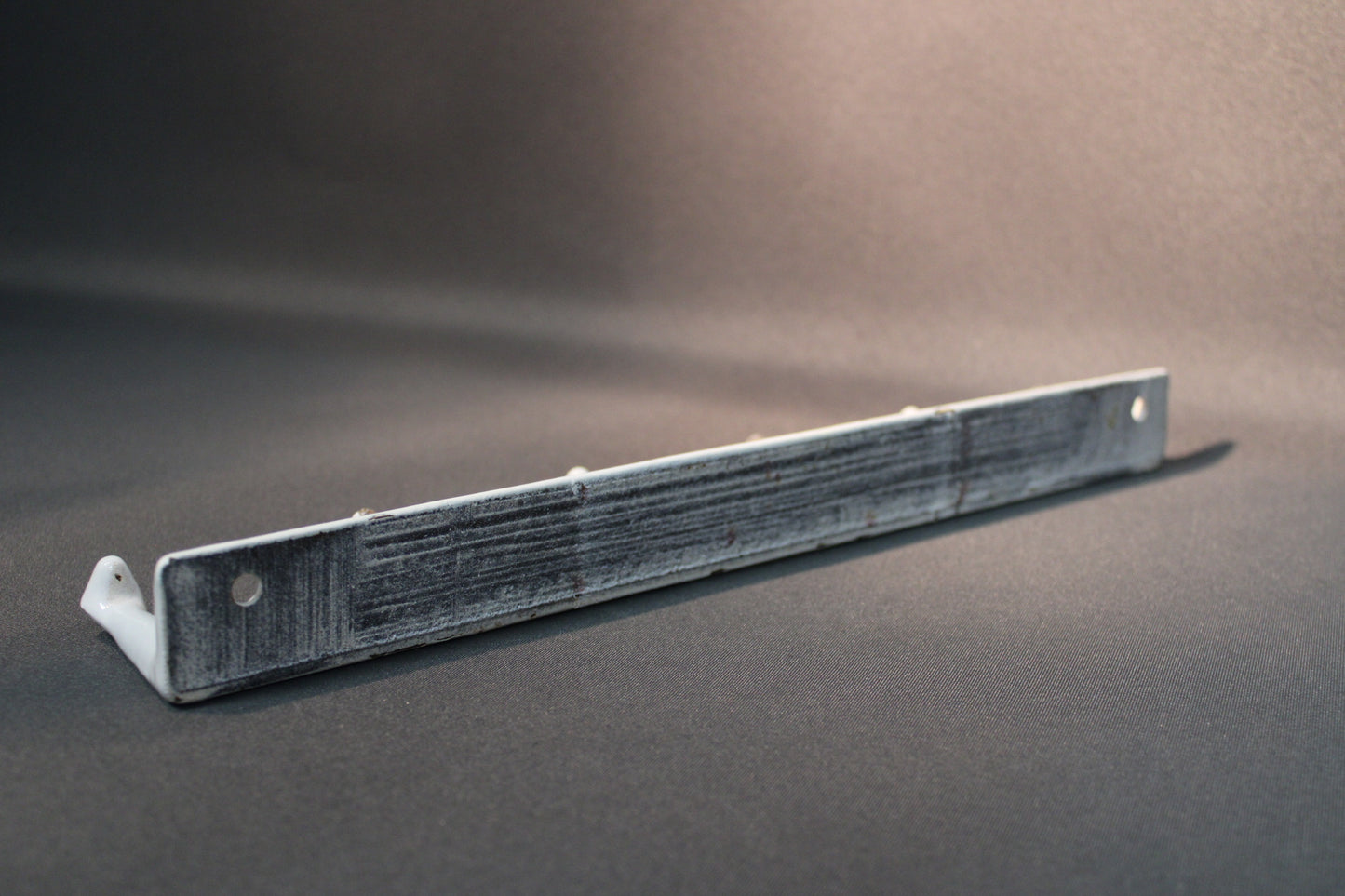 Metallinaulakon takapuoli, emalin alla käytön jälkiä