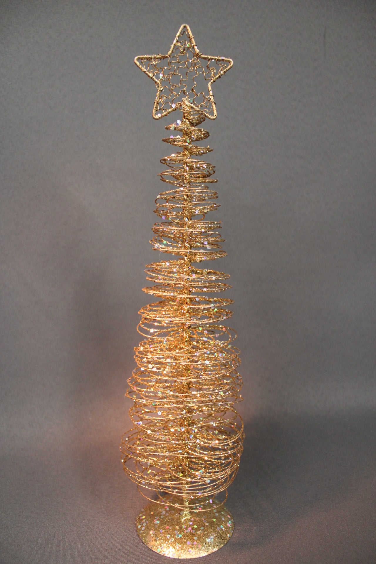 Kultainen metallinen koristekuusi spiraalirakenteella ja glitterillä, tähtikoriste latvassa