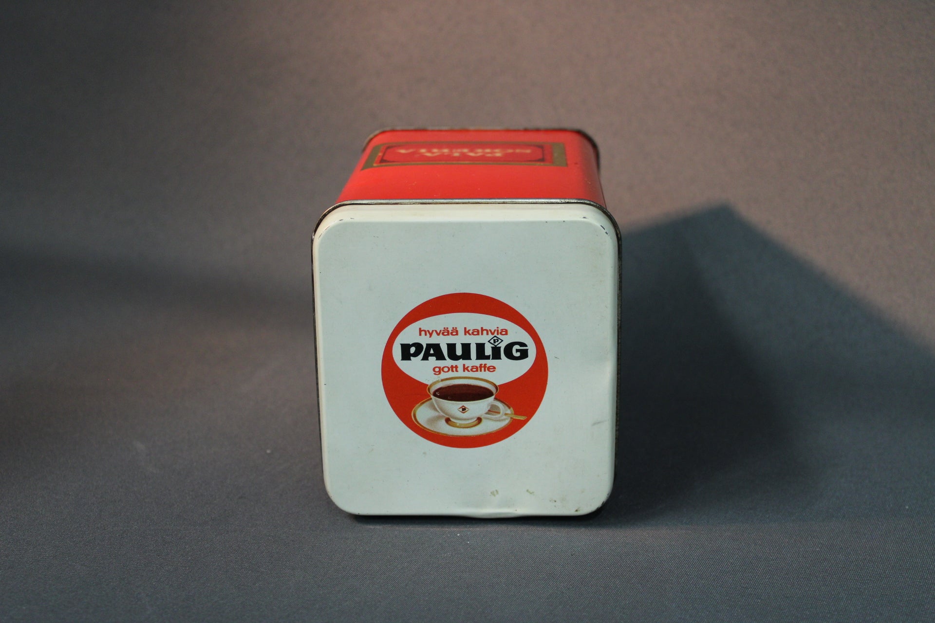 Paulig peltipurkin valkoinen kansi ja vanha Paulig-logo