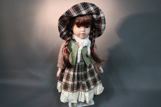 Posliininukke tyttö 40 cm, ruudullinen mekko ja hattu, edestä kuvattuna.