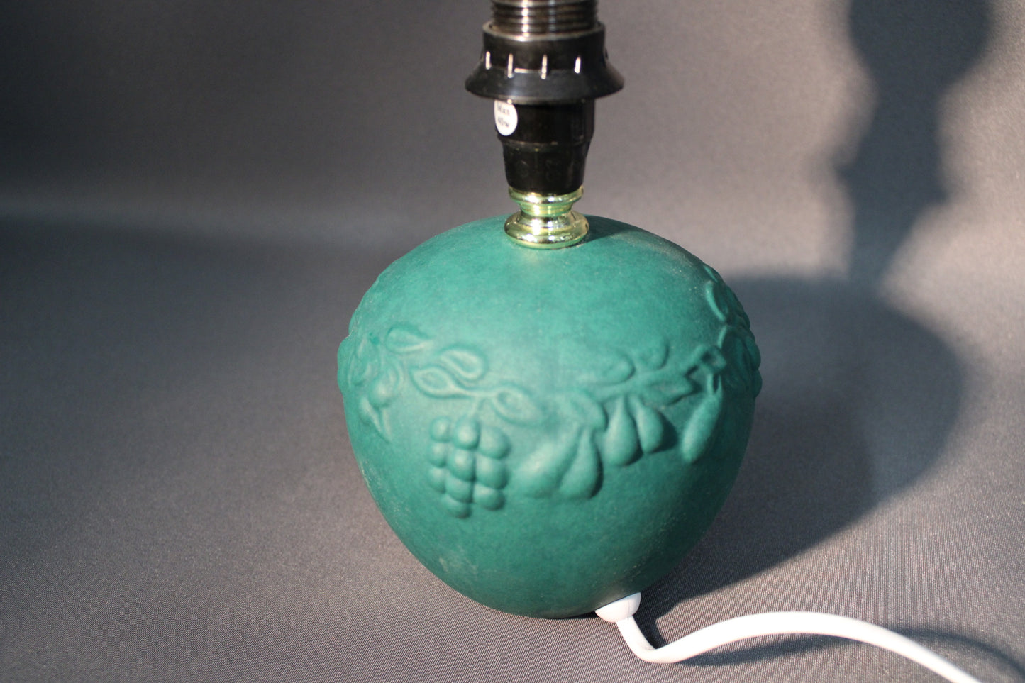 Pöytävalaisimen vihreä posliinipinta ja kohokuviointi lähikuvassa