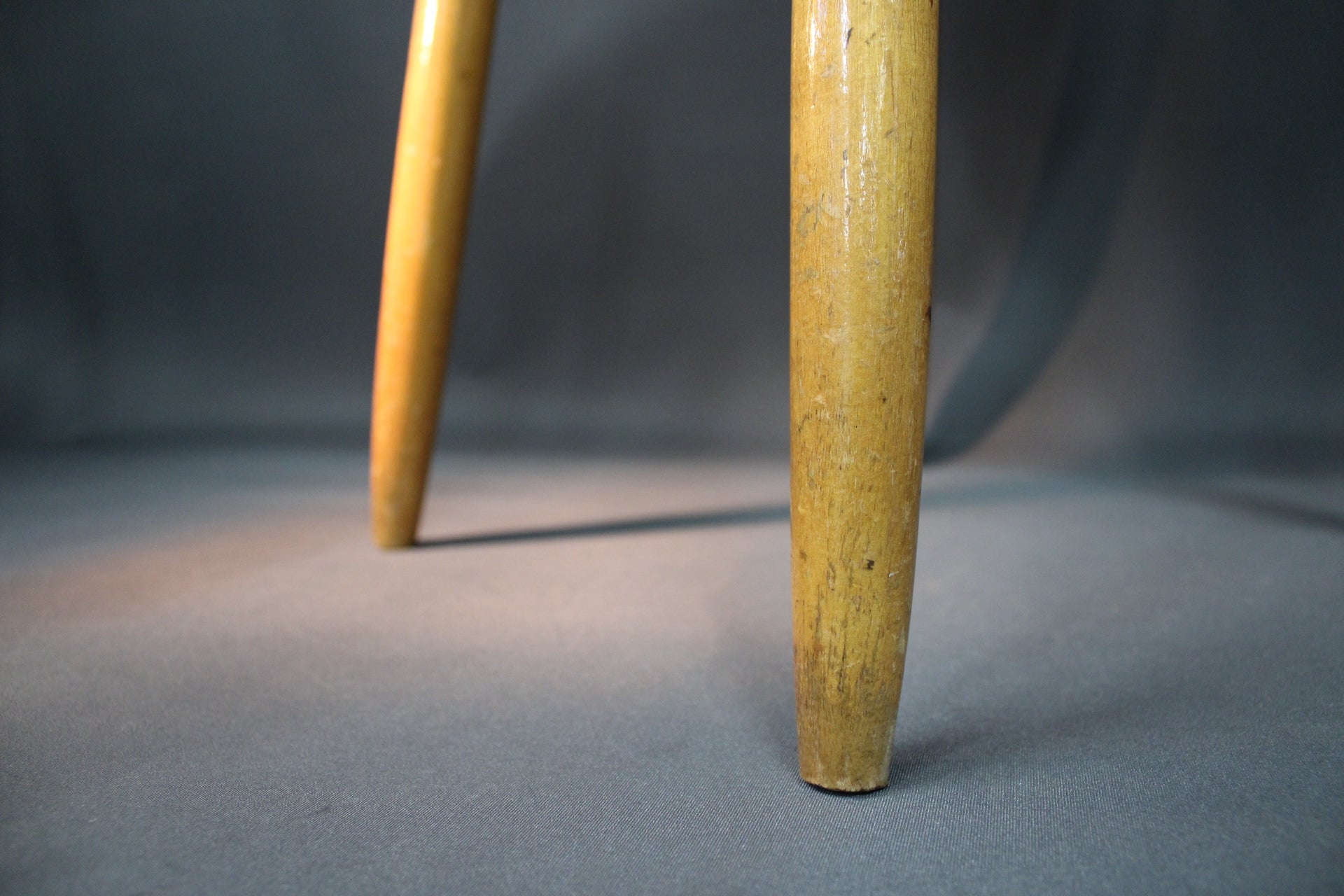 Puinen 1950-luvun tuoli, punainen istuin ja selkänoja, vaaleat puujalat,jalat läheltä