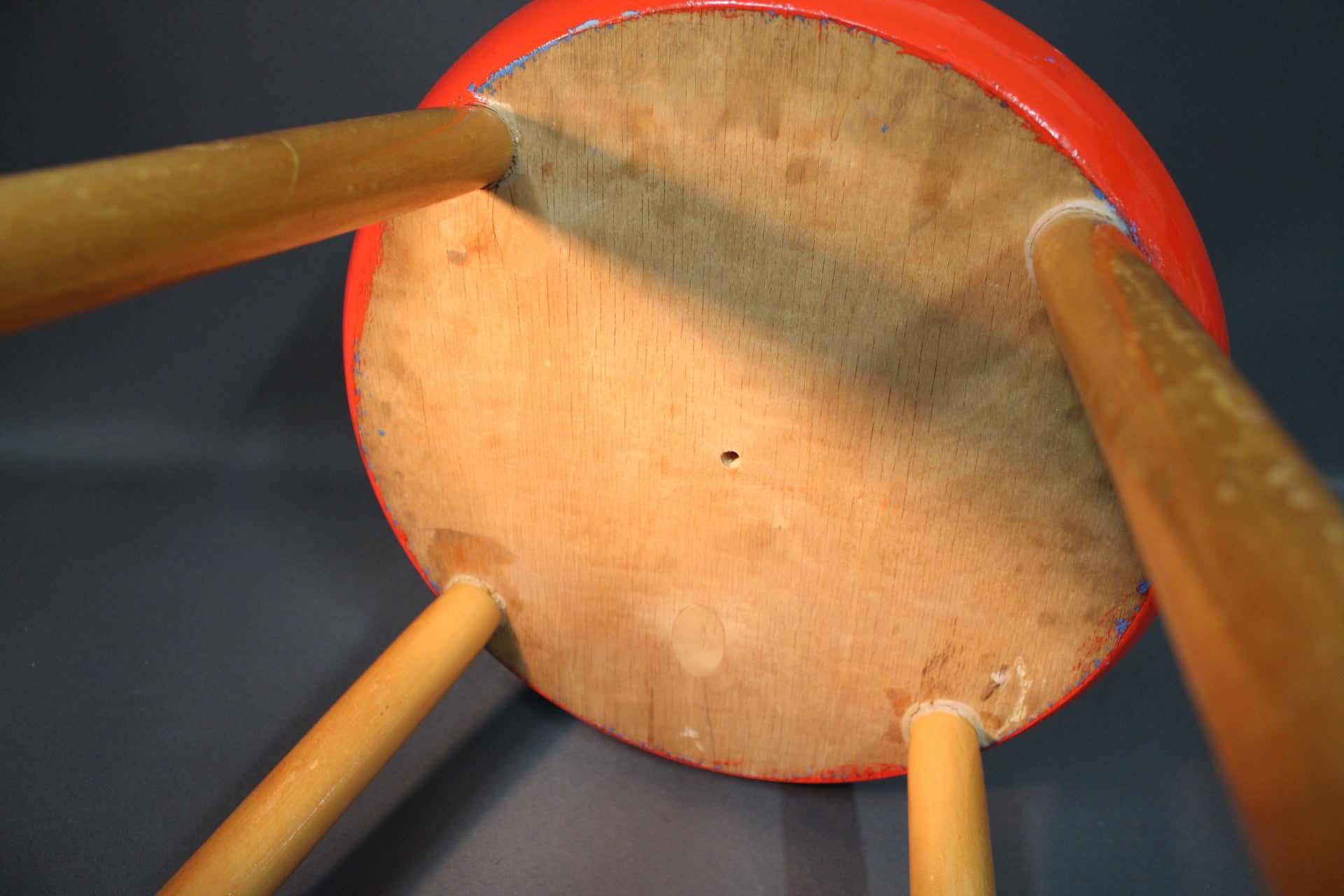 Puinen 1950-luvun tuoli, punainen istuin ja selkänoja,tuolin pohja,lähikuva