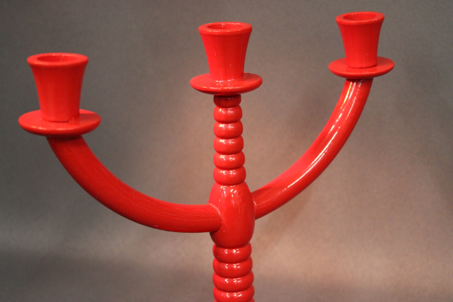 Punaisen puisen kynttilänjalan yksityiskohta, sorvattu keskirunko ja kynttiläpesät