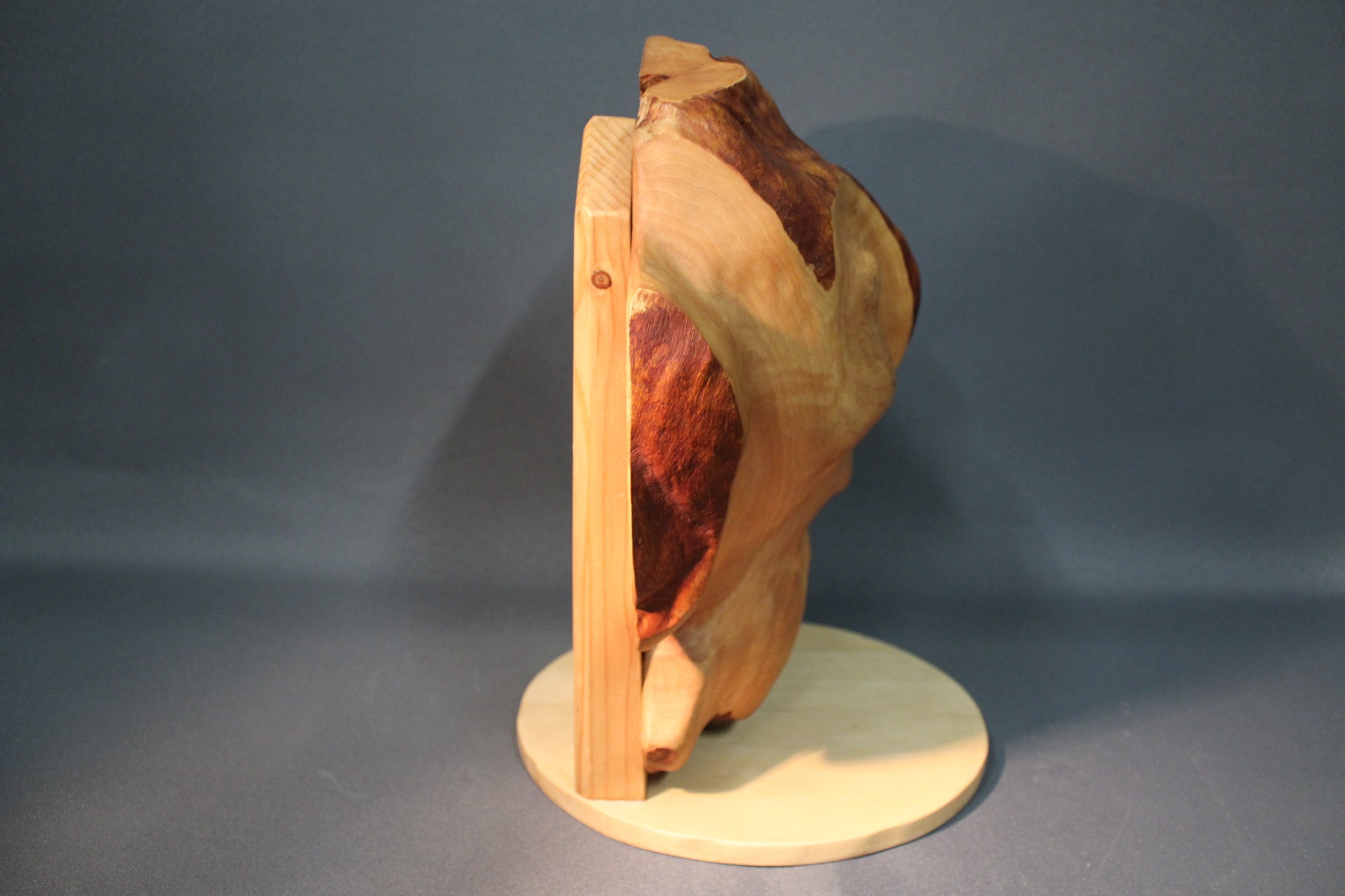 Käsin veistetty puuveistos sivulta, luonnollinen pintastruktuuri.