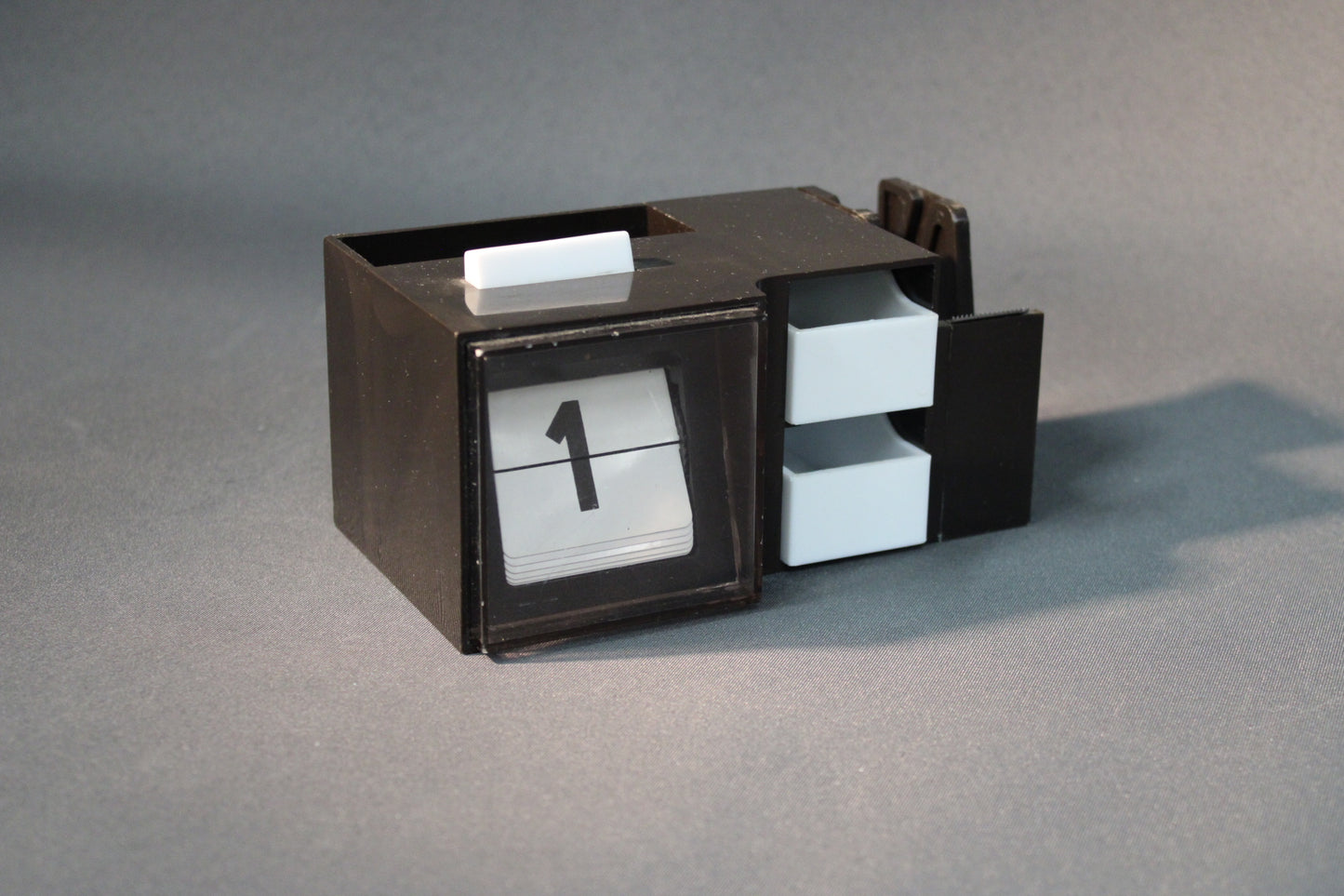 Retro pöytälipukekalenteri, ruskea runko ja valkoiset laatikot edestä kuvattuna.