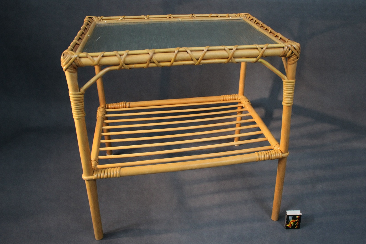 Rottinkinen apupöytä, punottu runko ja lasikansi, sivuprofiili