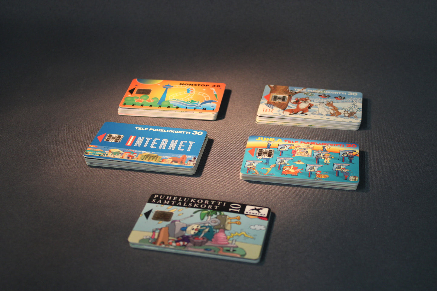 45 telekortin kokoelma pöydällä, erilaisia kuvituksia ja sarjoja