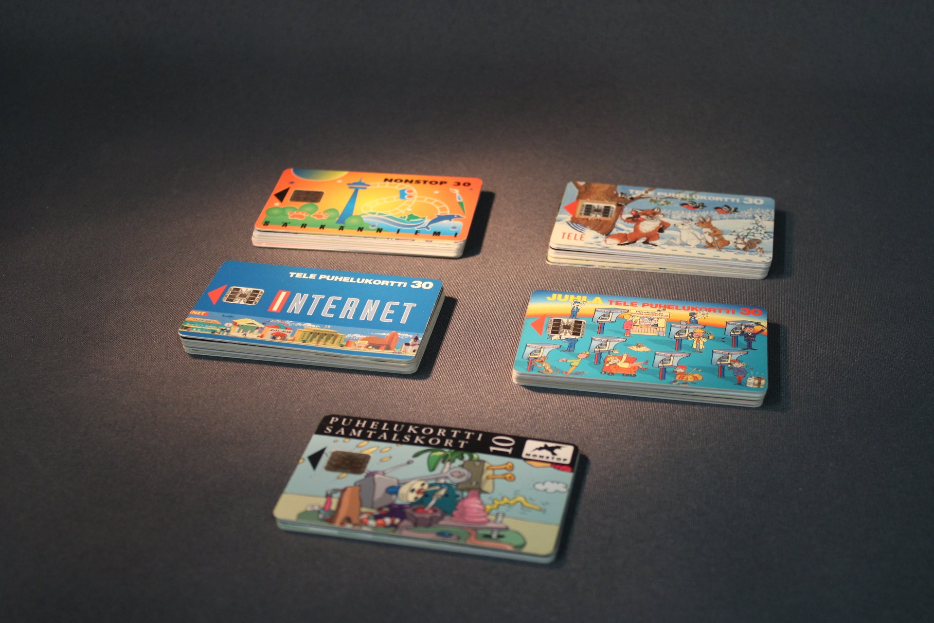 45 telekortin kokoelma pöydällä, erilaisia kuvituksia ja sarjoja