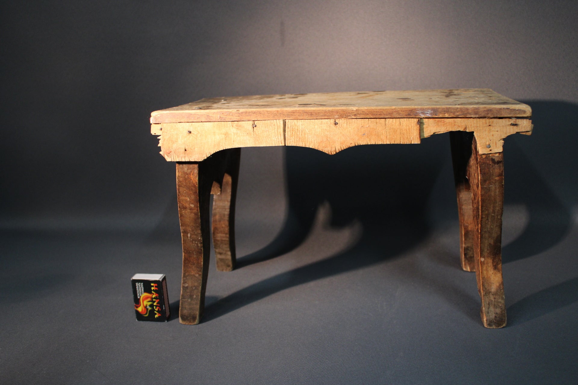 Vanha puinen jakkara sivusta, ajan patinoima pinta ja rustiikkinen ilme