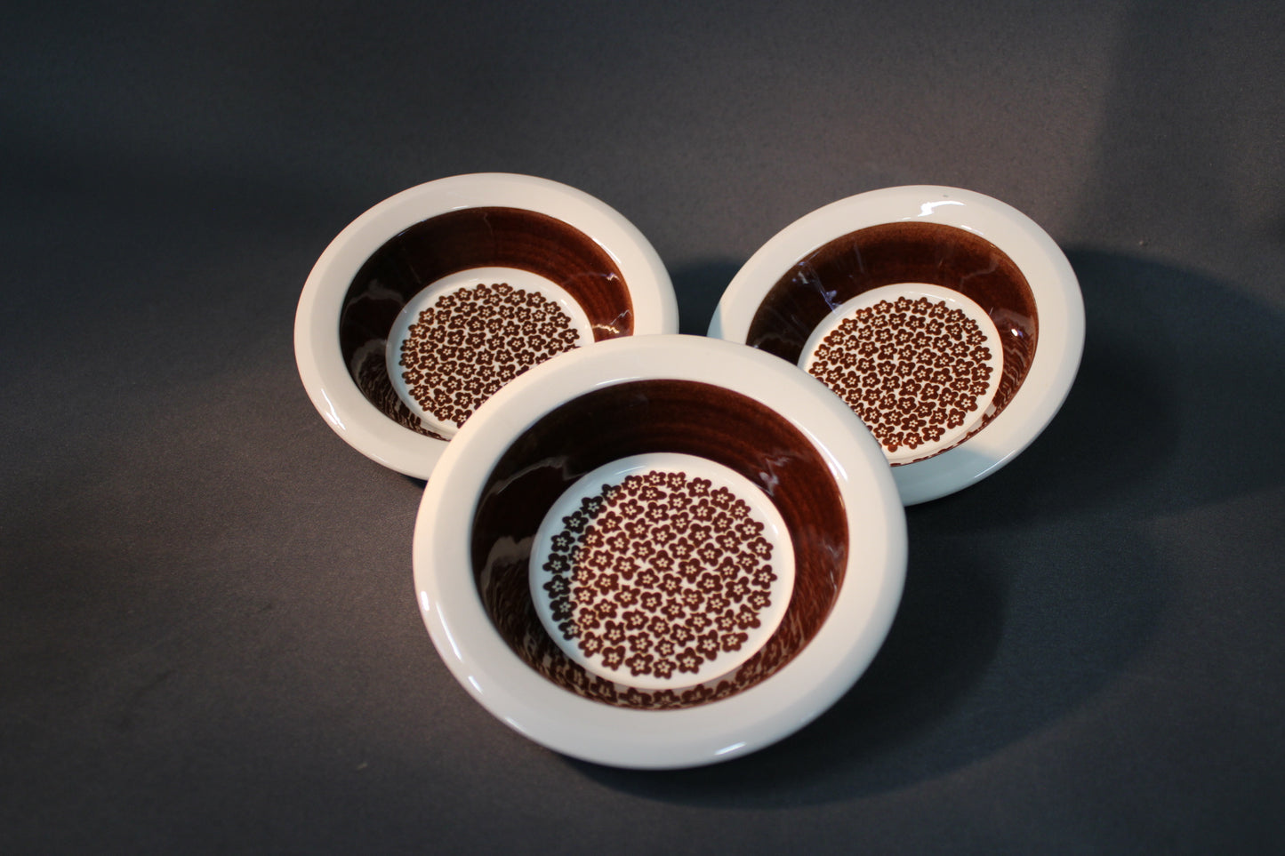 Kolme Arabia Faenza -kulhoa ruskeakukka-kuviolla vierekkäin