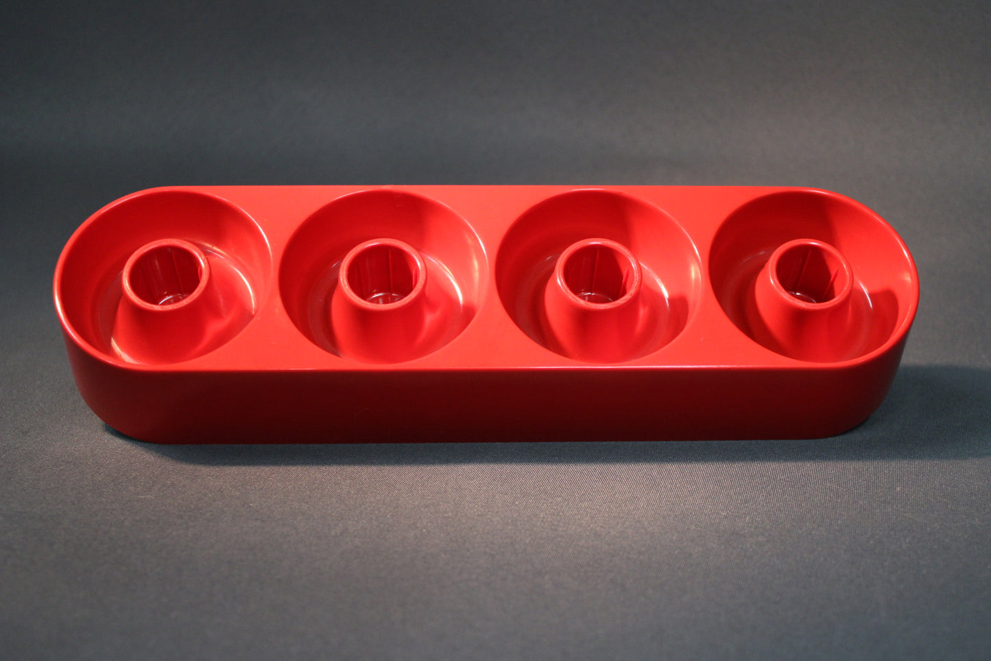Retro punainen nelipaikkainen kynttilänjalka ylhäältä kuvattuna, muovinen